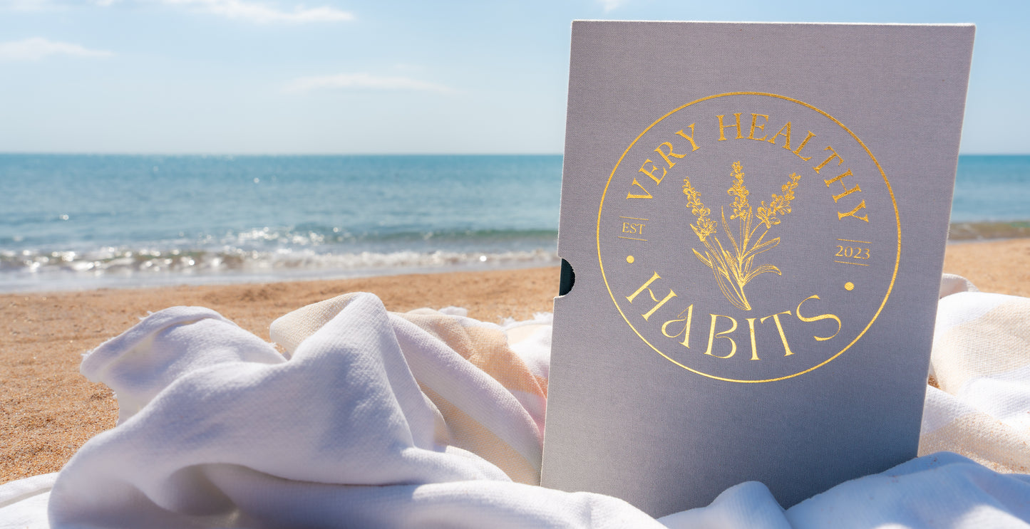 Very Healthy Habits Gratitude and Manifestation Journal set on a beach